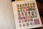 Fyndlåda (bananlåda) med både album och lösa märken på blad. Ett ganska välfyllt Världen-album m.m.