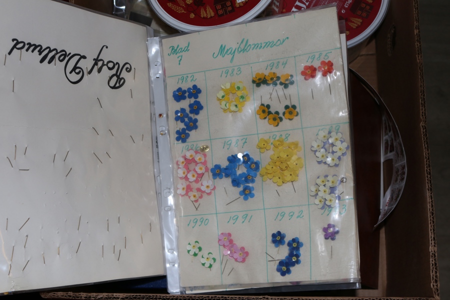 Bananlåda blandat material, både svenskt och utländskt. Ett album Polen, ett album FN, album svenska försändelser, bältespännarmaterial majblommor, tvättade frimärken i burkar et.c.